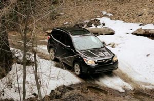 Subaru Vehicle Driving Through Snow