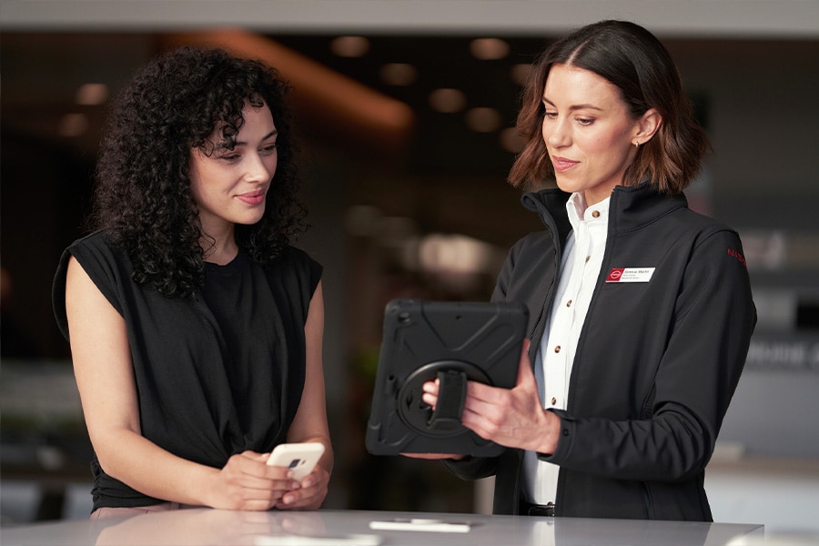 Woman reviewing information on Tablet held by Financial Manager