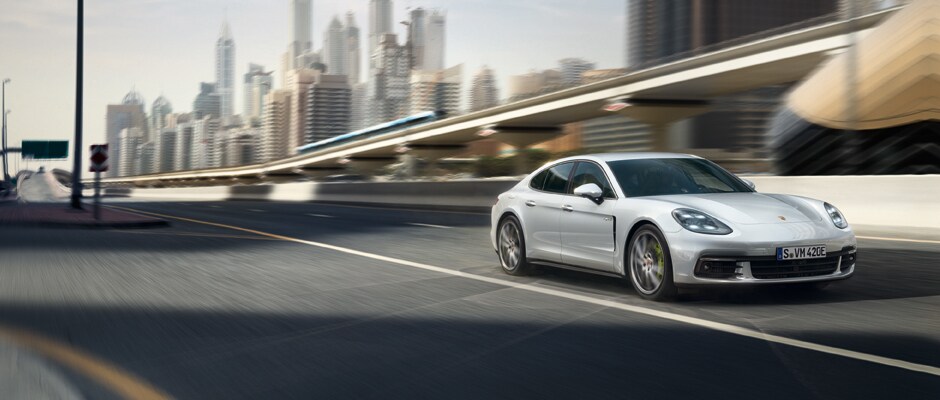 Porsche Panamera E-Hybrid Models A silver Porsche Panamera E-Hybrid driving down a highway