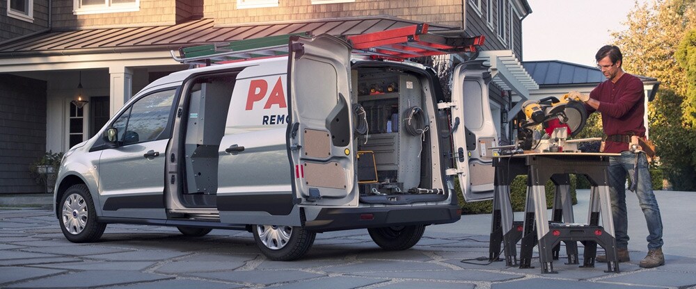 man woodworking out of a Ford van