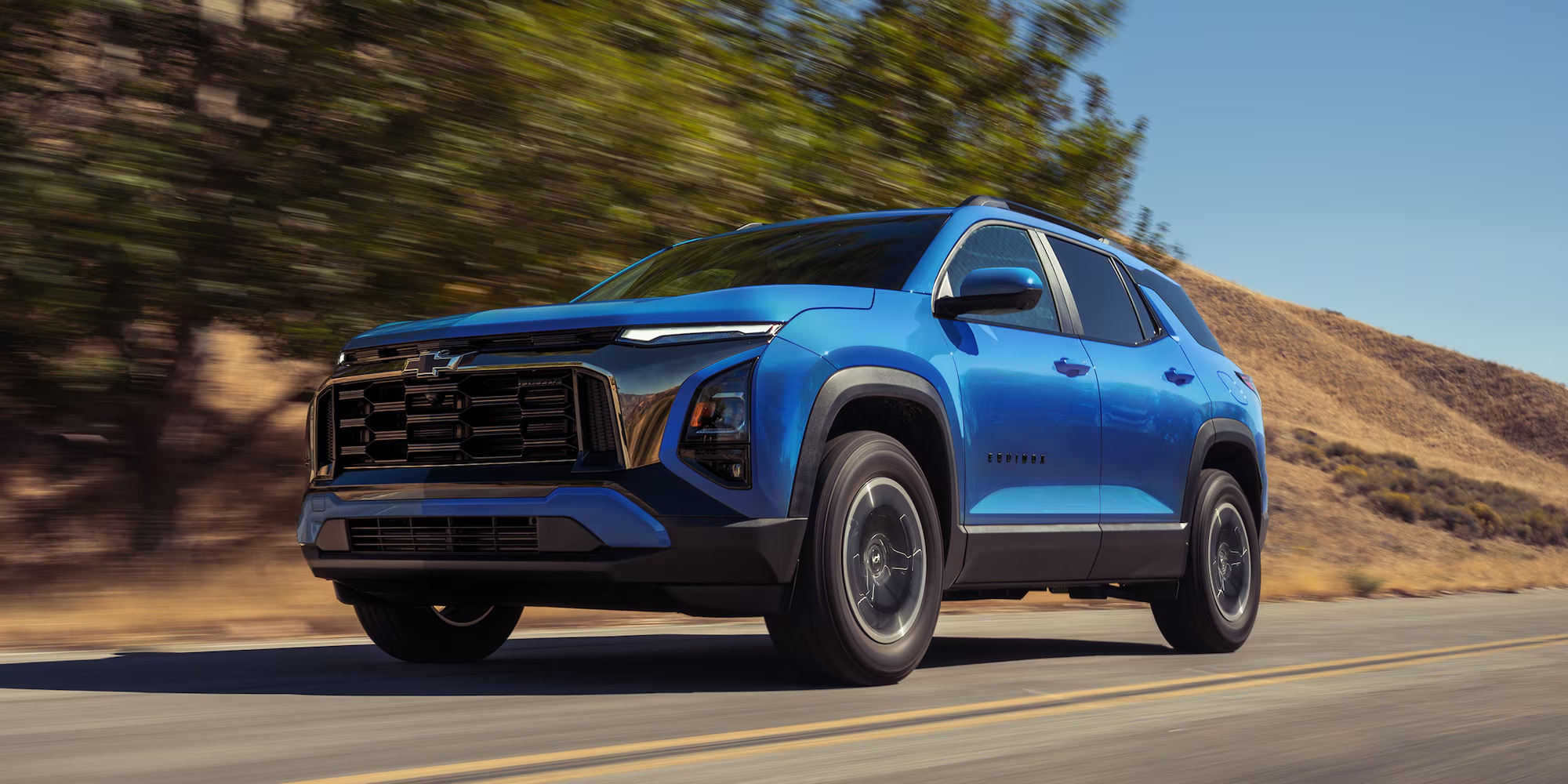 Blue 2027 Chevrolet Equinox cruising down a road