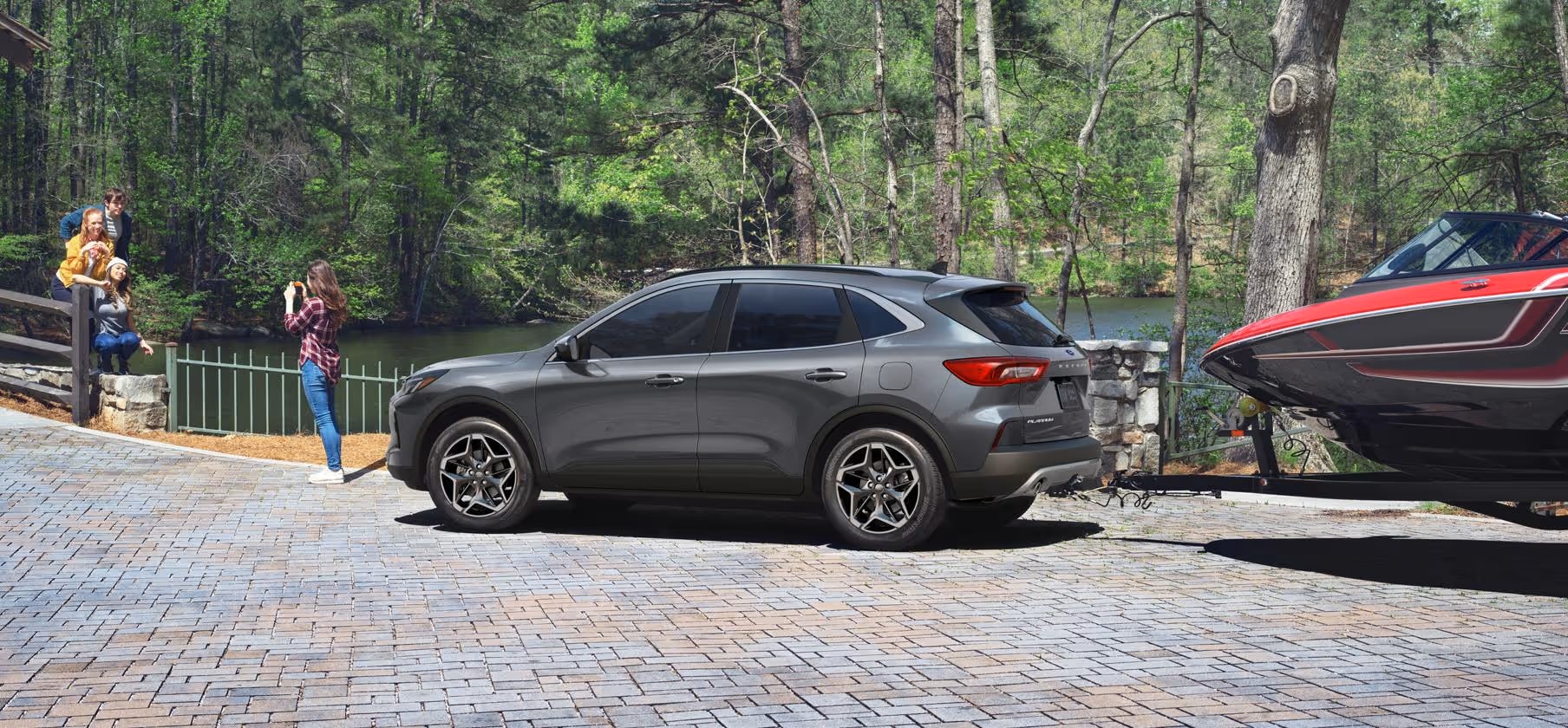 2026 Ford Escape towing a boat while family takes photos