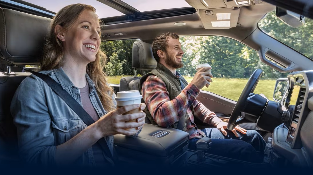 Couple holding coffee cups in a Ford SUV