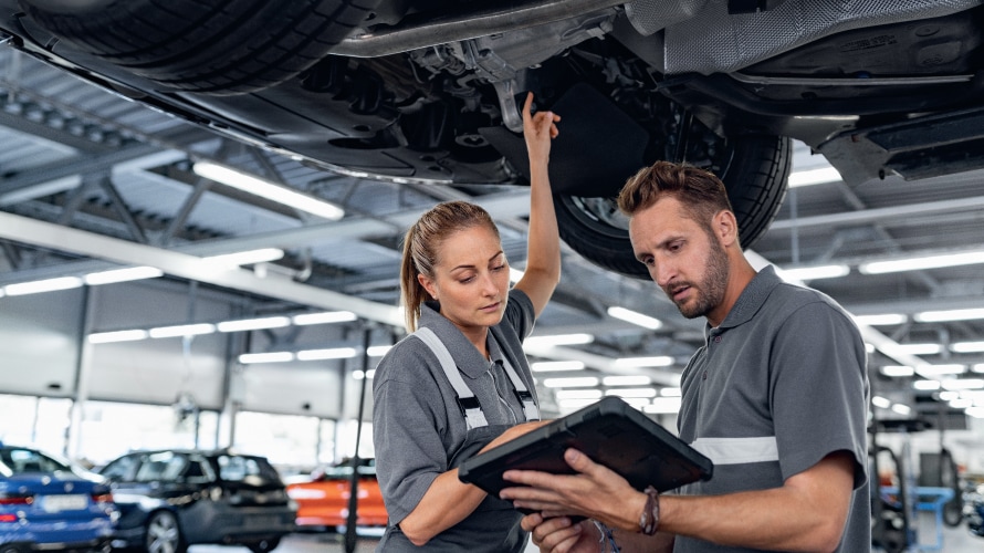 BMW Service technicians examining vehicle