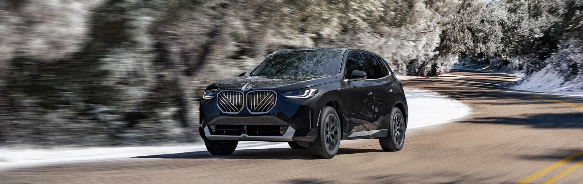  BMW X3 driving on a neighborhood road.