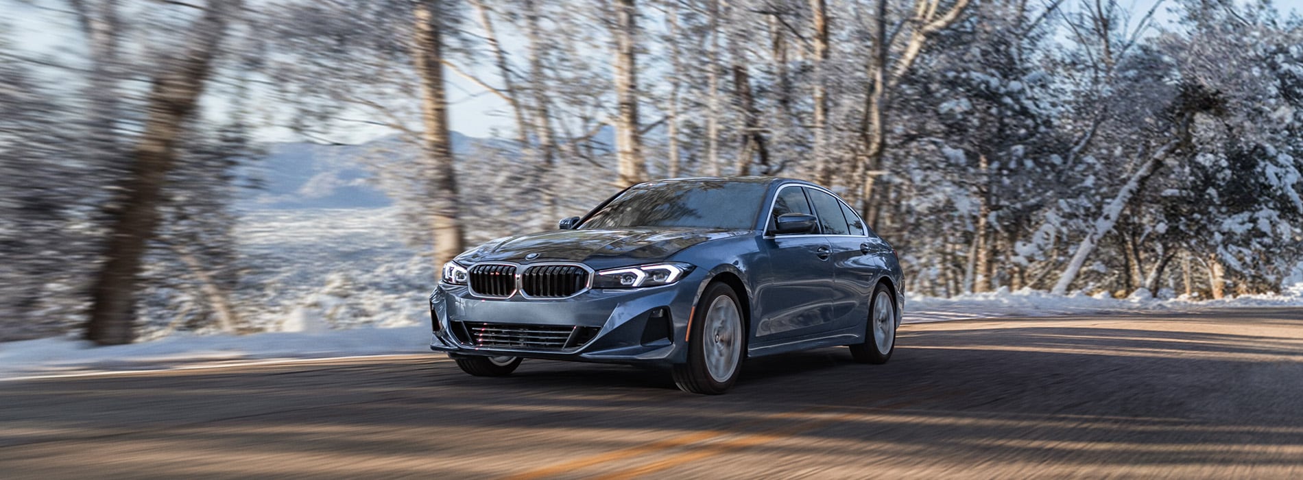BMW 3 series driving on a road.