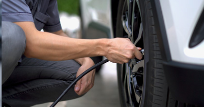 Technician checking the tire pressure on a BMW