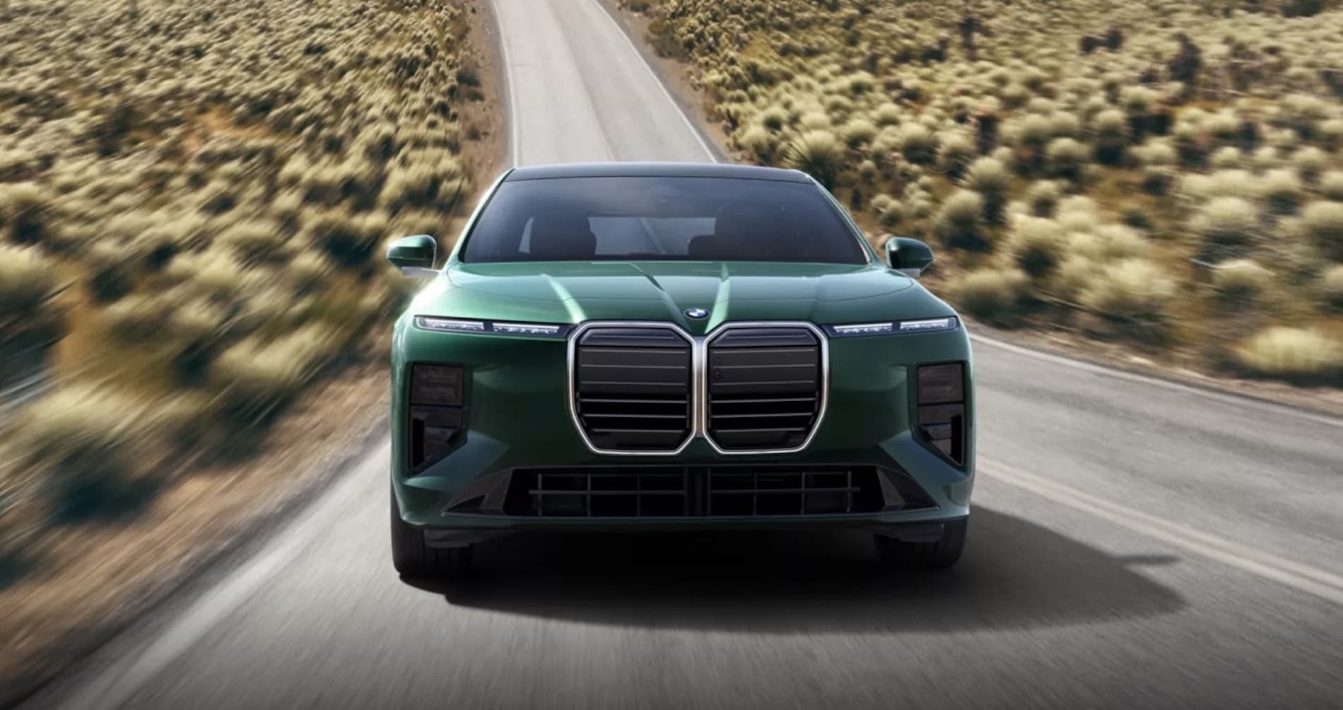 2027 BMW 7 Series Sedan exterior in green, head-on on an open road