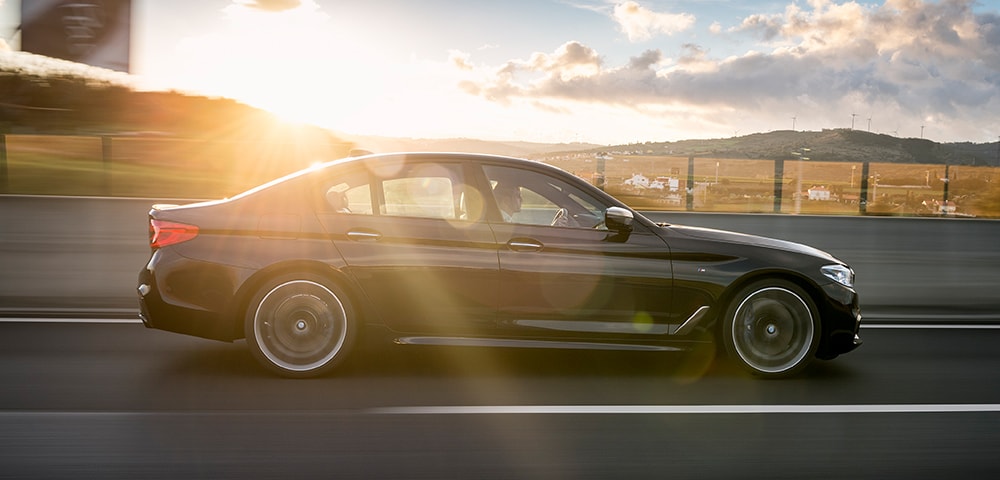 Side shot of a 2018 BMW M550i xDrive driving down the road