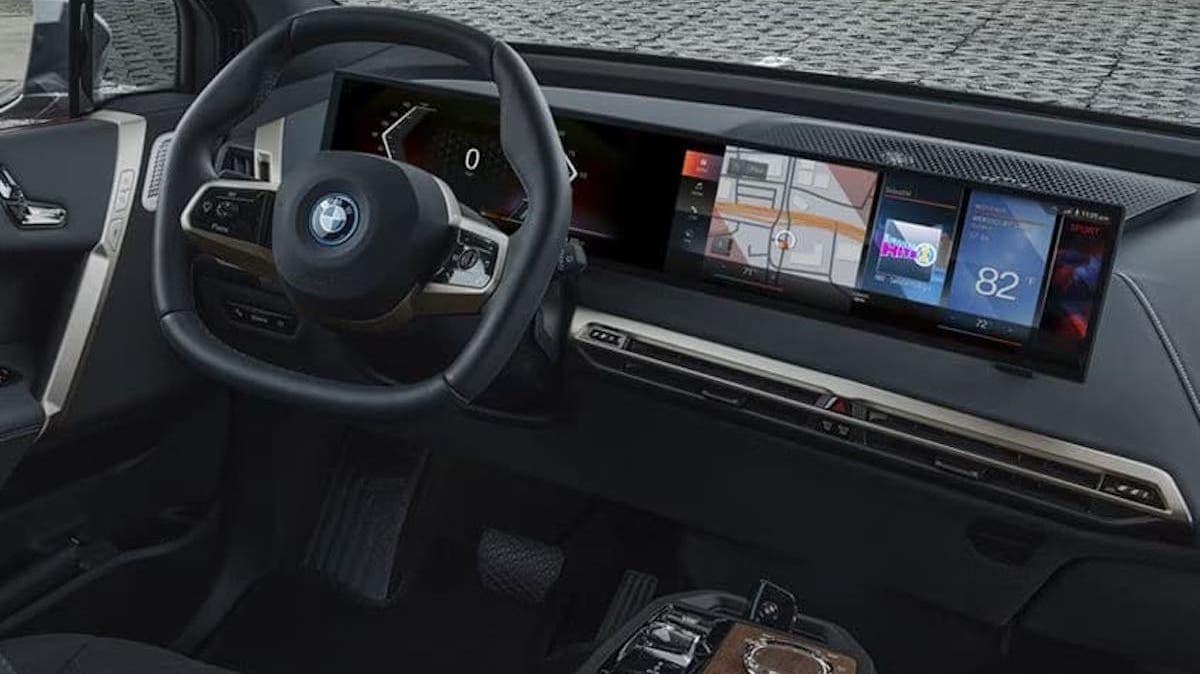 Side view of a BMW iX driving through rain
