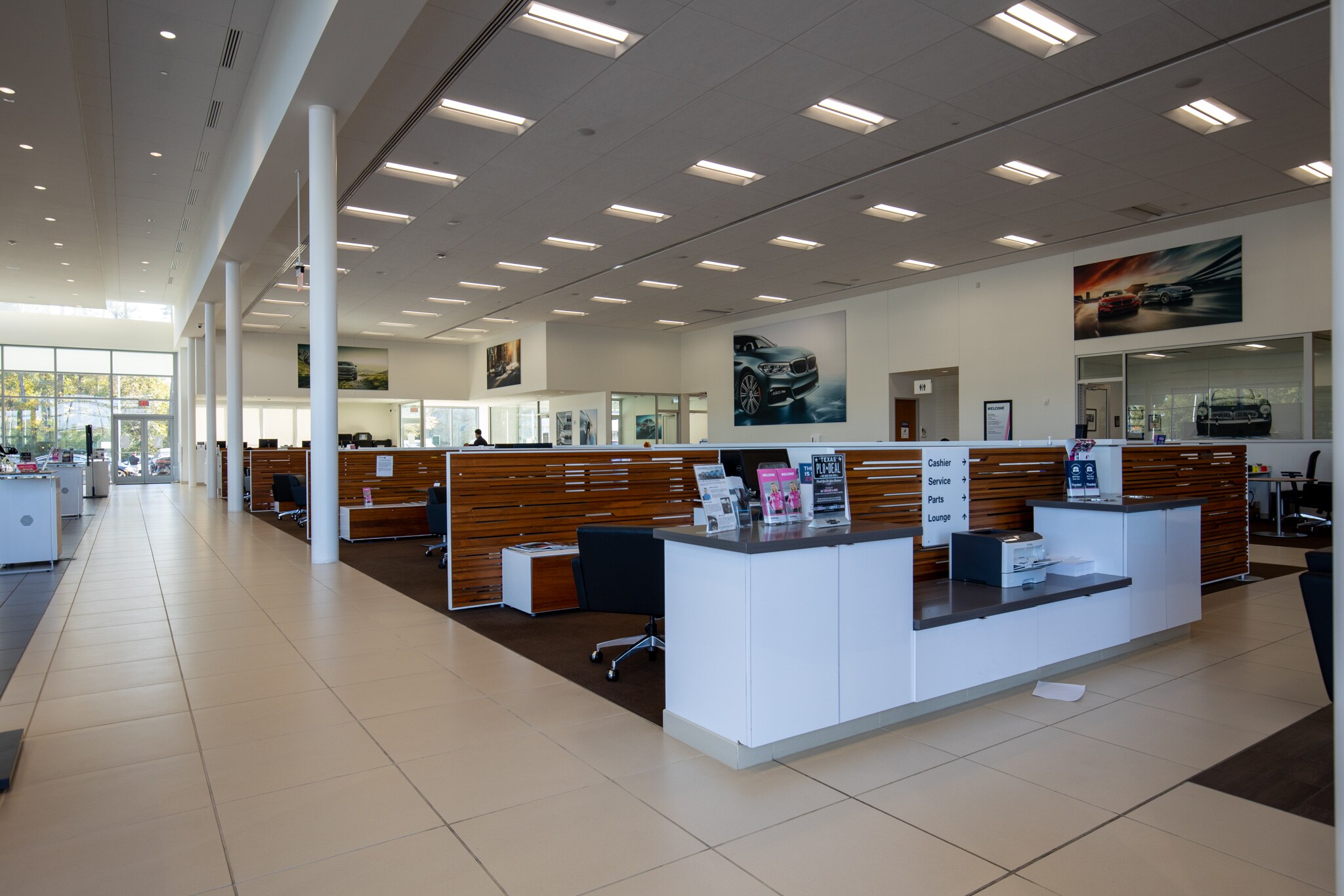 Interior view of BMW of The Woodlands, featuring several bays of desks and chairs.