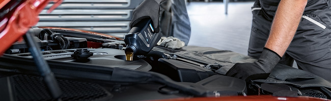 Close up of service technician pouring oil