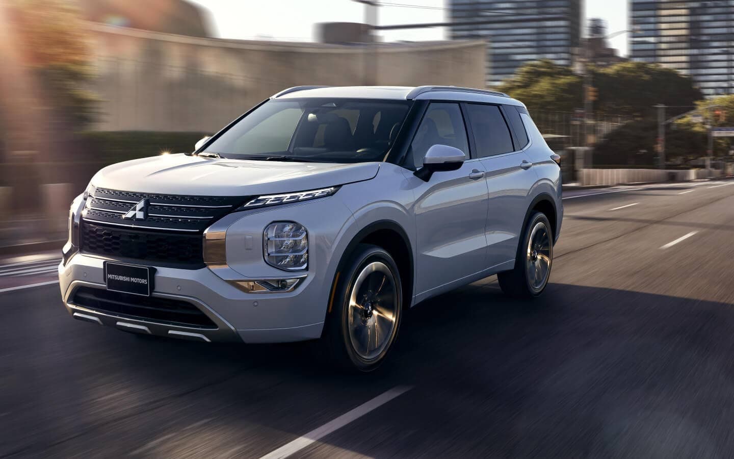 Silver Mitsubishi Outlander driving down a city street.jpeg