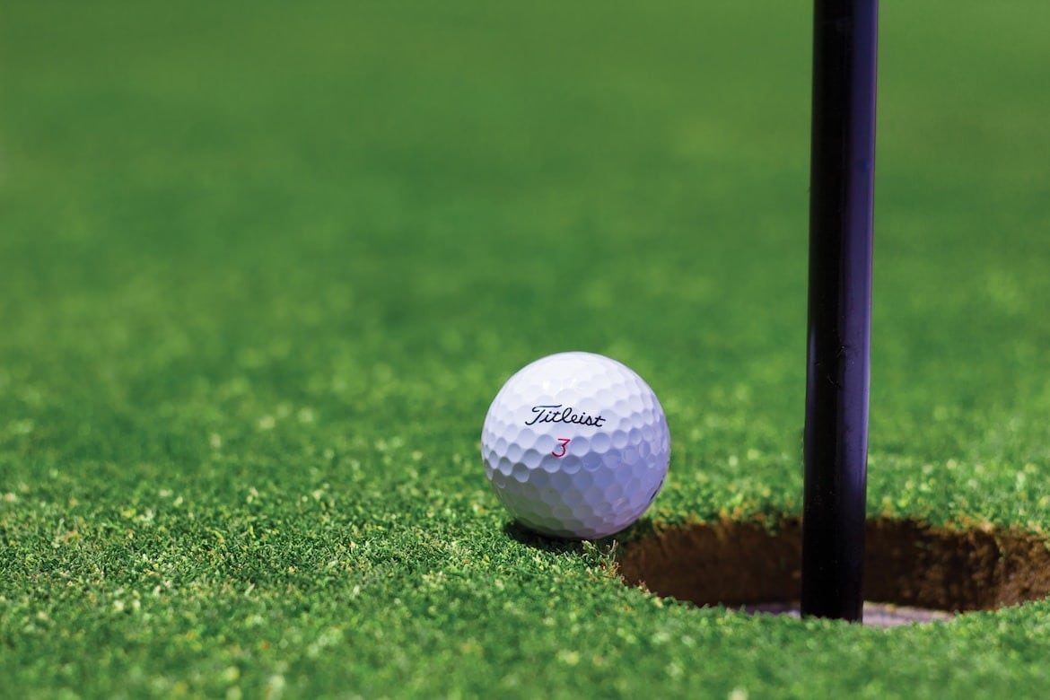 golf ball sitting next to a tee.jpeg