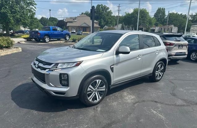A silver Mitsubishi Outlander Sport crossover parked in an outdoor parking lot.png