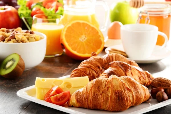 crossiants, cheese, and fruit for a breakfast