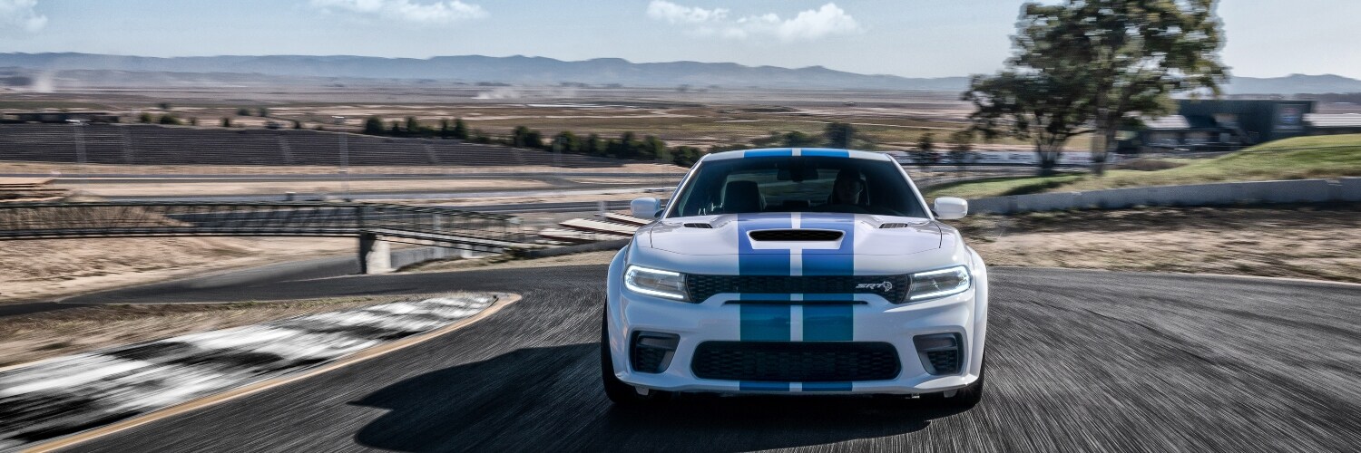 green Dodge Charger driving on a performance track