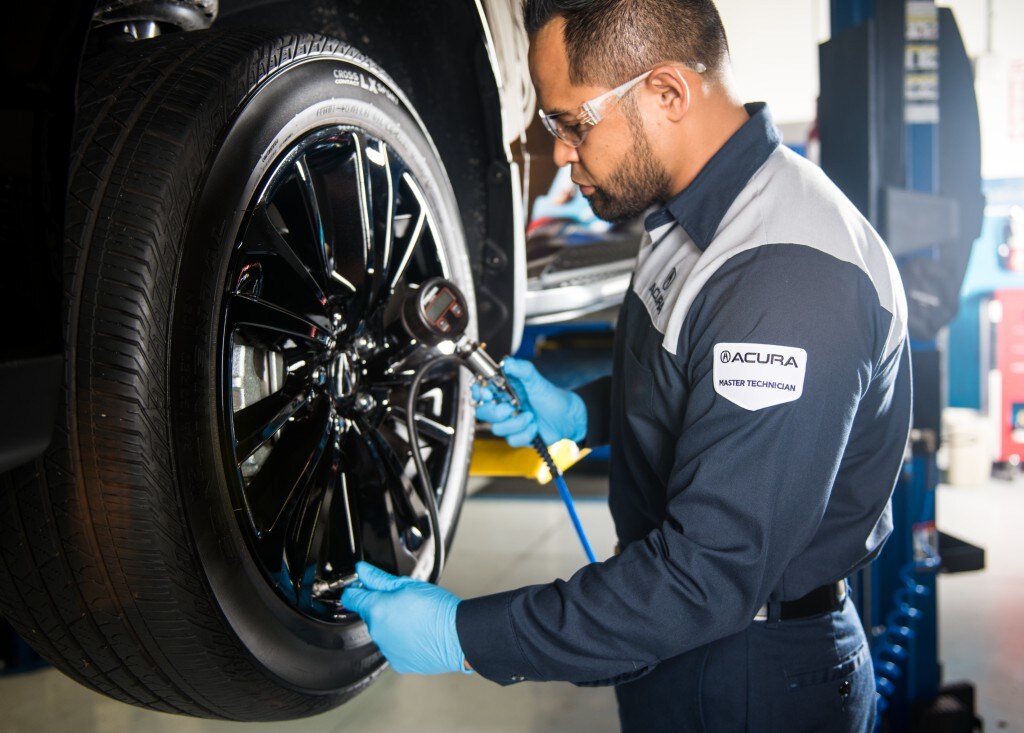 How to check your tires' health at Bobby Rahal Acura of Mechanicsburg | Acura service technician checking tire pressure on an Acura vehicle