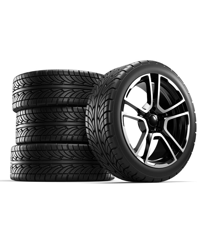 Winter Tires vs. All Season Tires at Bobby Rahal Acura in Mechanicsburg, PA | Three Tires Stack One on Top of the Other and a Fourth Wheel Upright Sitting Next to the Pile