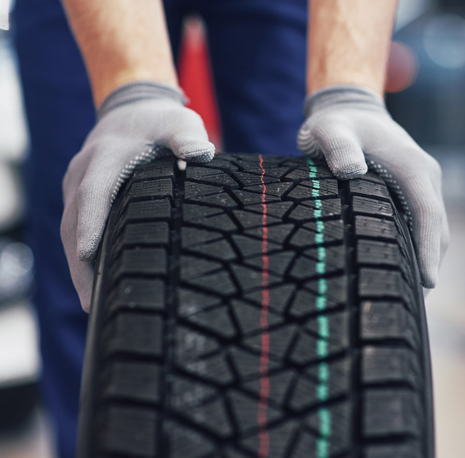 What is a Tire Rotation? at Bobby Rahal Acura | Two Hands on a Car Tire Pushing Forward