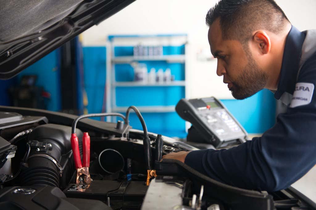 Basic Car Maintenance and Servicing Checklist | Bobby Rahal Acura | Acura service technician checking battery in vehicle