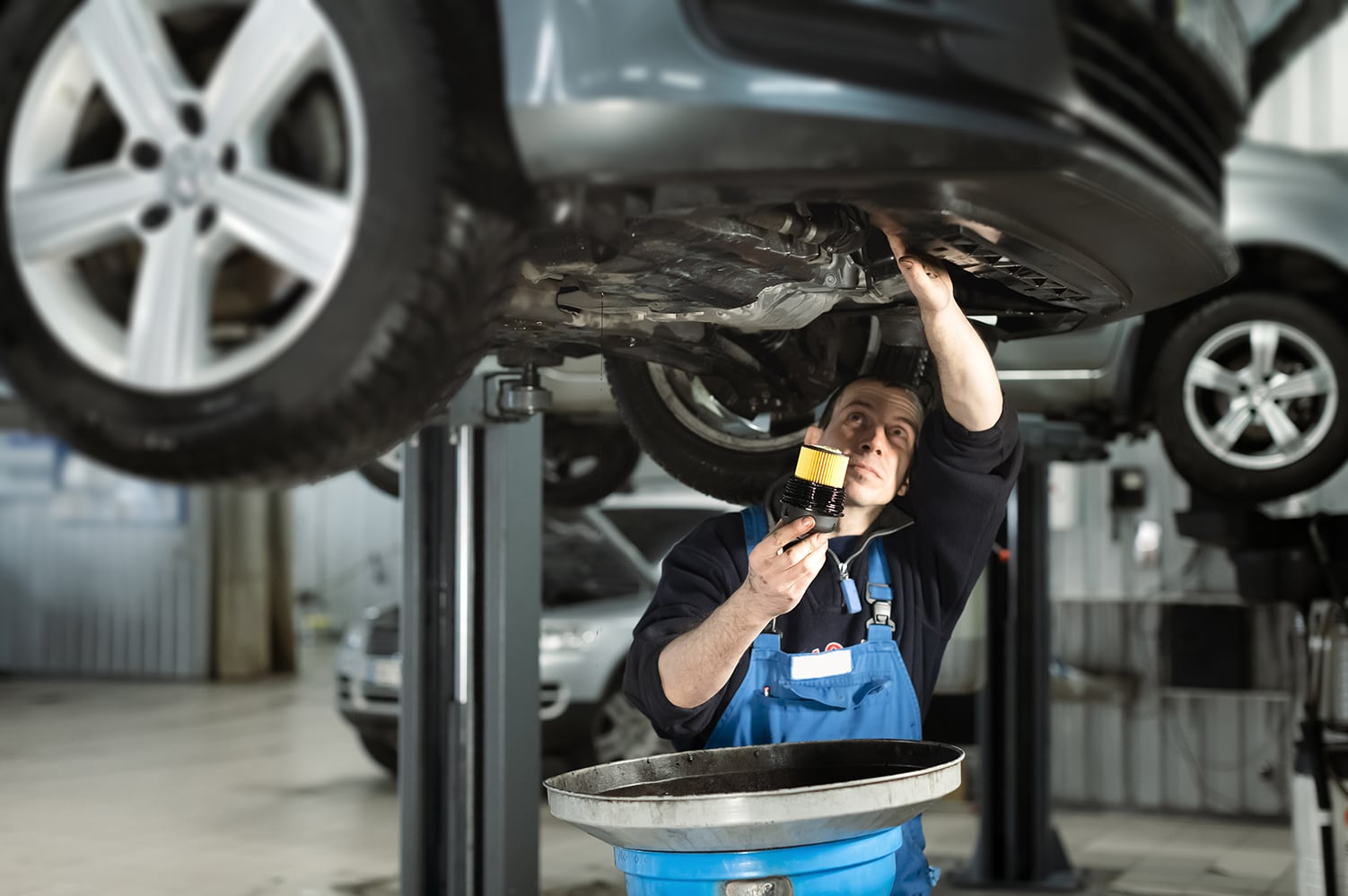Bobby Rahal Acura is a Car Dealership near Enola PA | Service technician changing oil in a vehicle