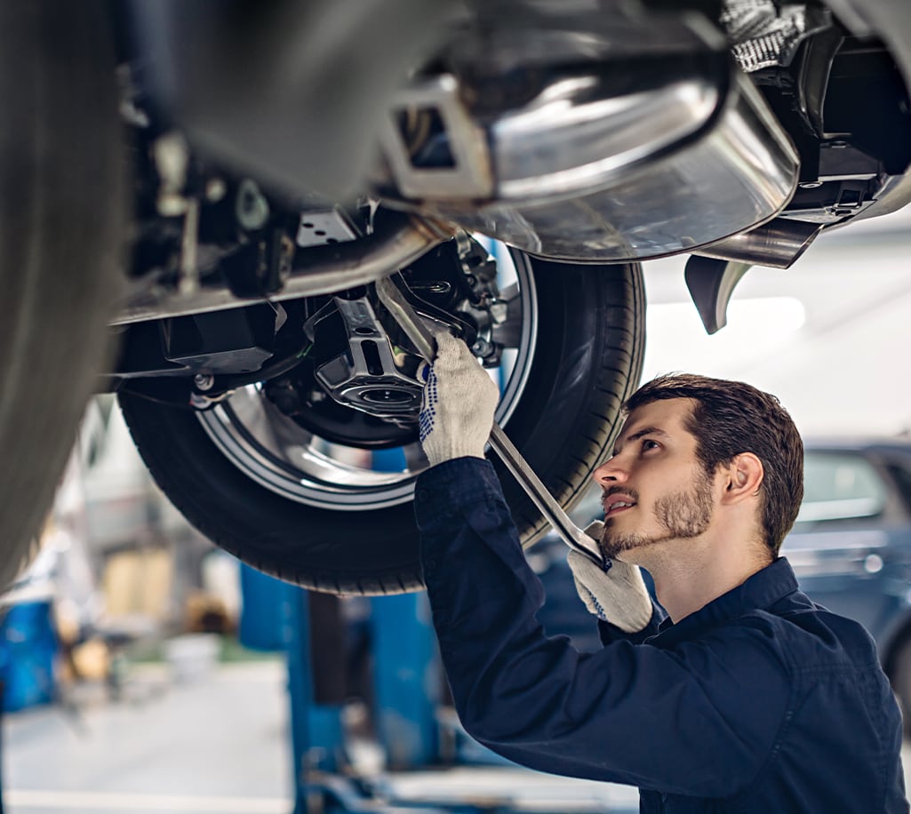 What is included in a Multi-Point Inspection? | Bobby Rahal Acura in Mechanicsburg, PA | Mechanic inspection underneath a car while using a long tool