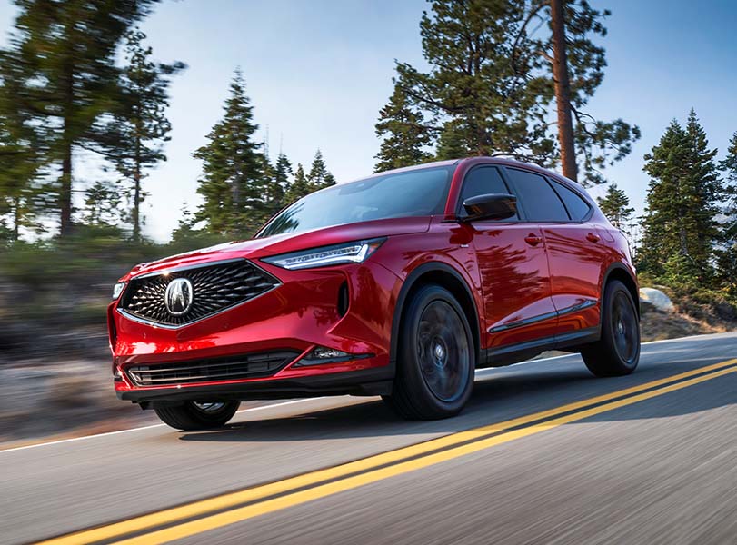 Model Features of the 2022 Acura MDX at Bobby Rahal Acura | Red 2022 Acura MDX Driving Around Bend On Country Road