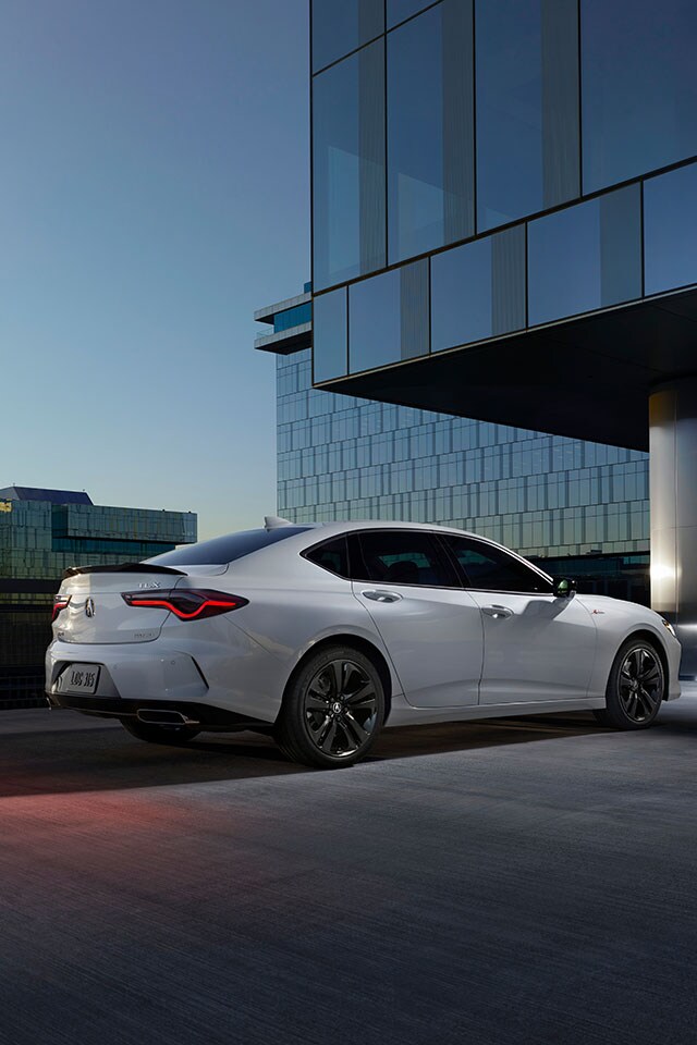 Leasing versus Buying a Acura at Bobby Rahal Acura in Mechanicsburg, PA | White Acura TLX A-Spec Parked Under a Building at Dusk Facing Right Away From Camera