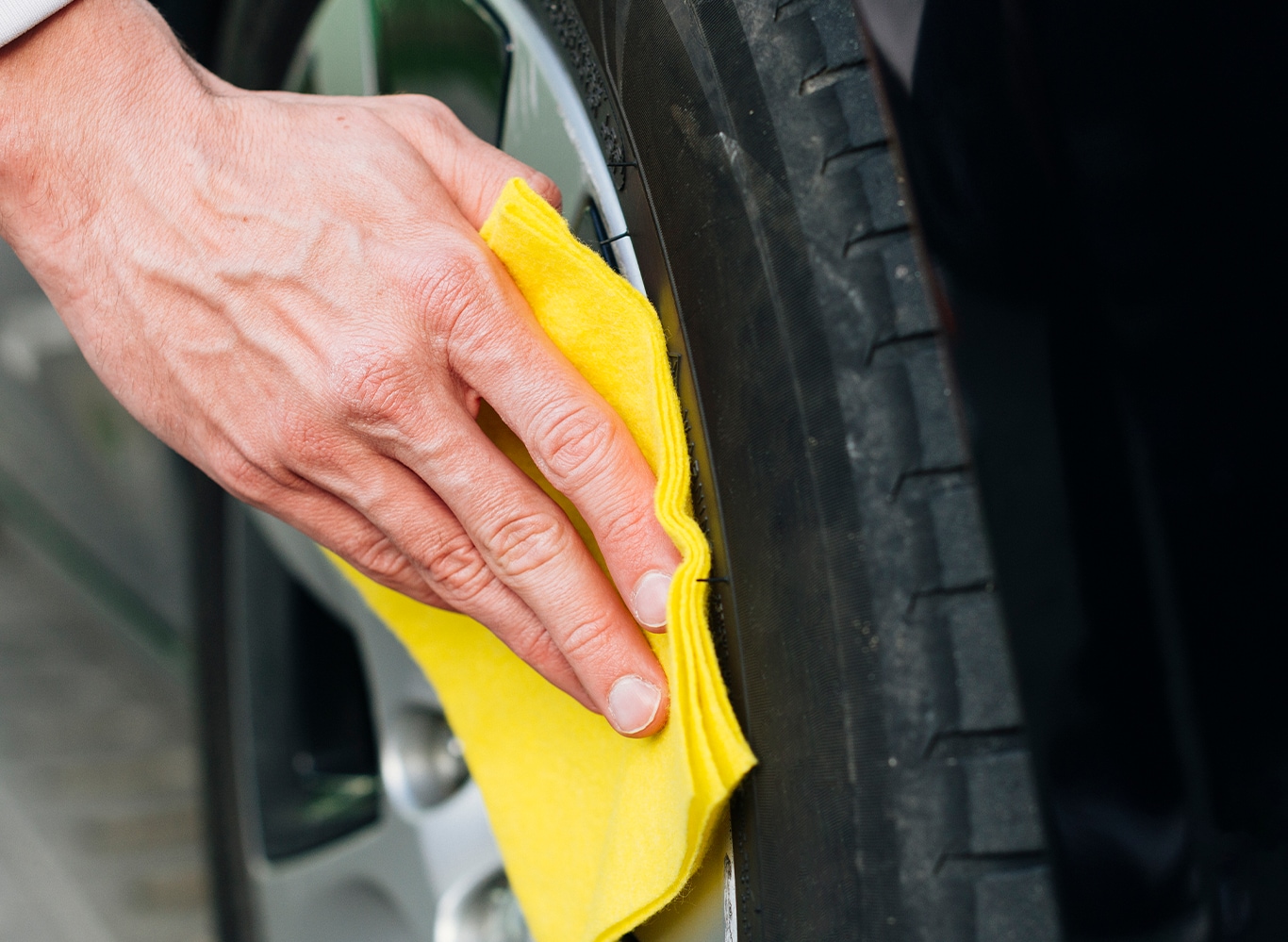 What is Tire and Rim Protection? | Bobby Rahal Acura | Person with yellow cloth wiping dirt of their rims