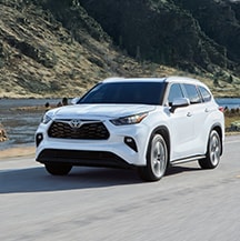 Model Features of the 2021 Toyota Highlander at Bobby Rahal Toyota | Highlander driving on a sunny day
