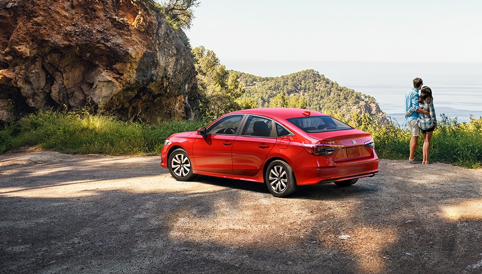 The Top 3 Most Fuel-Efficient Honda Models at Bobby Rahal Honda of State College | Rear view of the red Honda Civic parked on a hill beside a couple 