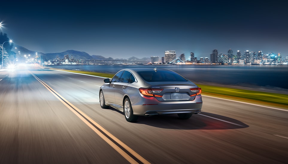 The Top 3 Most Fuel-Efficient Honda Models at Bobby Rahal Honda of State College | Rear view of a grey Honda Accord driving down the road at night 