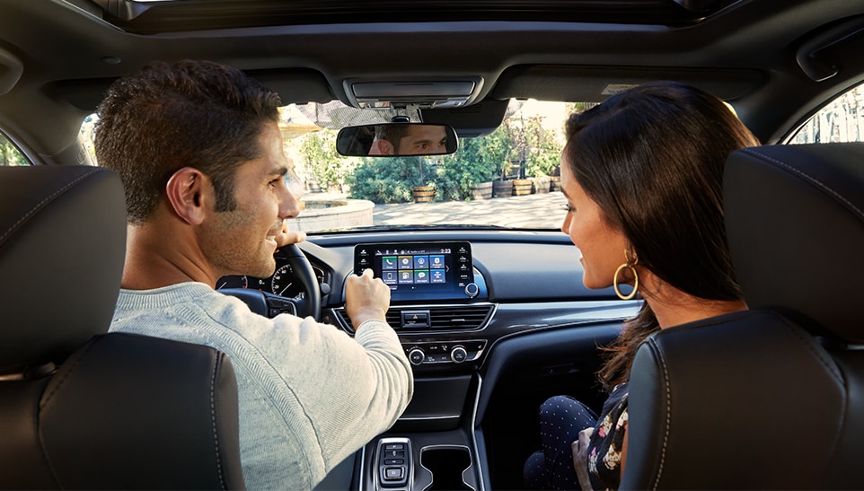 The Top 3 Most Fuel-Efficient Honda Models at Bobby Rahal Honda of State College | Interior shot of a Honda Accord with a man sitting in the drivers seat and a women sitting in the passangers seat