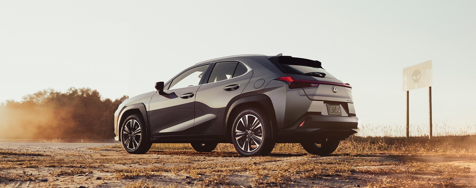 2025 Lexus UXh | Rear profile of a parked 2025 Lexus UX hybrid in the middle of a open field