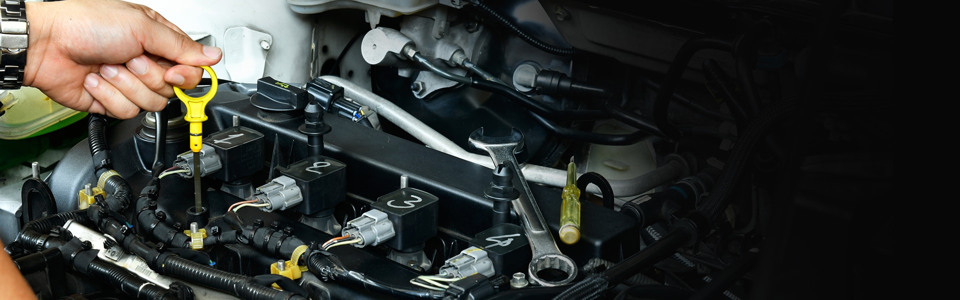 Benefits of Changing Your Toyota’s Oil at Bobby Rahal Toyota in Mechanicsburg | Toyota Technician pulling the oil dipstick from an engine to check it's condition