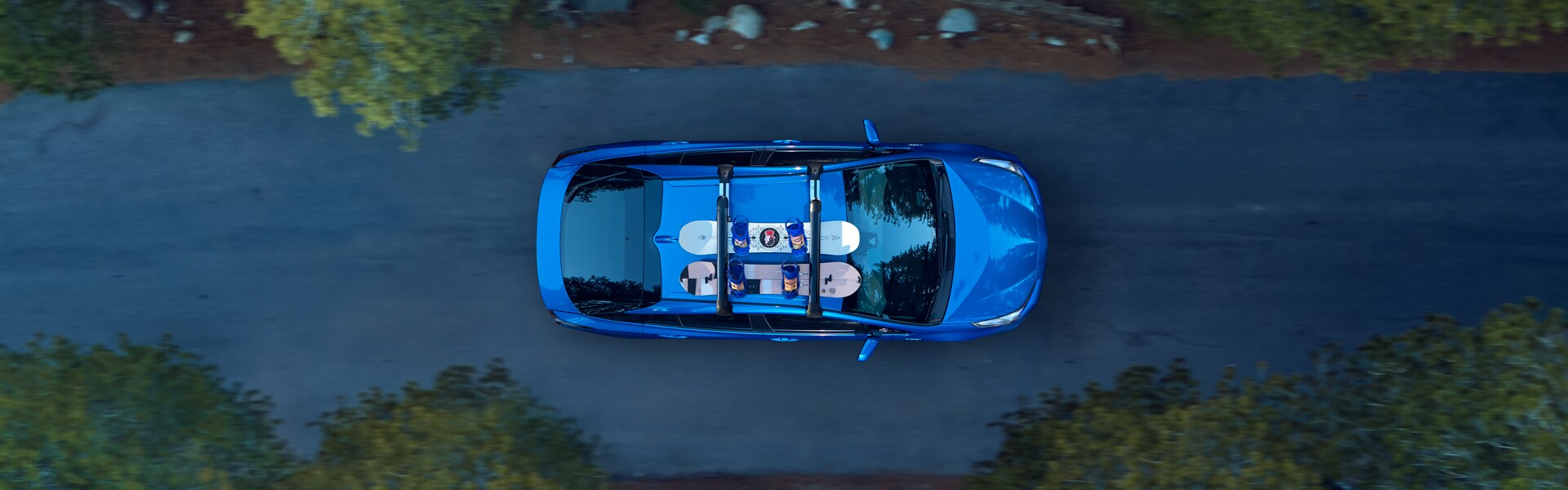 Defining APR at Bobby Rahal Toyota in Mechanicsburg, PA | The 2021 Toyota Prius XLE From a Bird's Eye View Driving Through a Forest With Two Snowboards Strapped to the Top