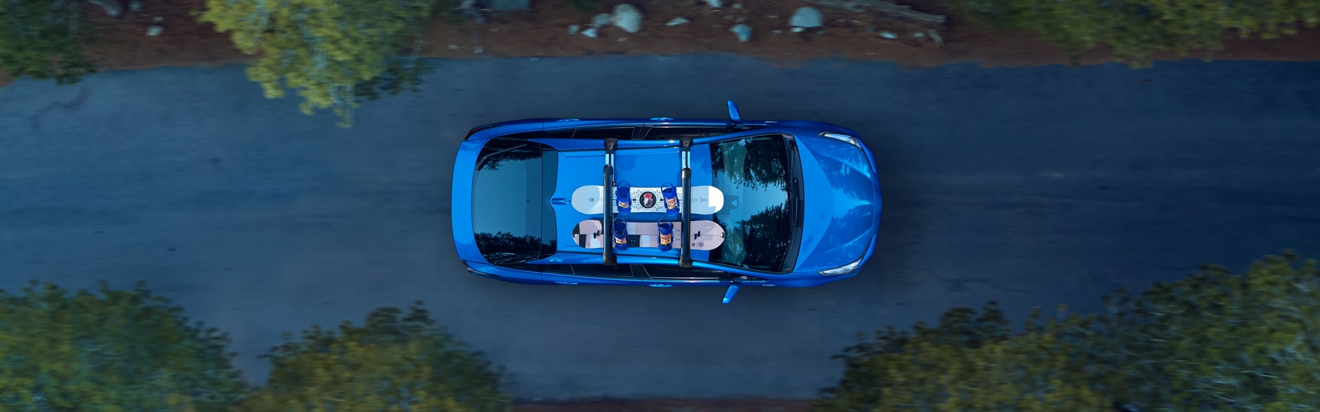 Defining APR at Bobby Rahal Toyota in Mechanicsburg, PA | The 2021 Toyota Prius XLE From a Bird's Eye View Driving Through a Forest With Two Snowboards Strapped to the Top