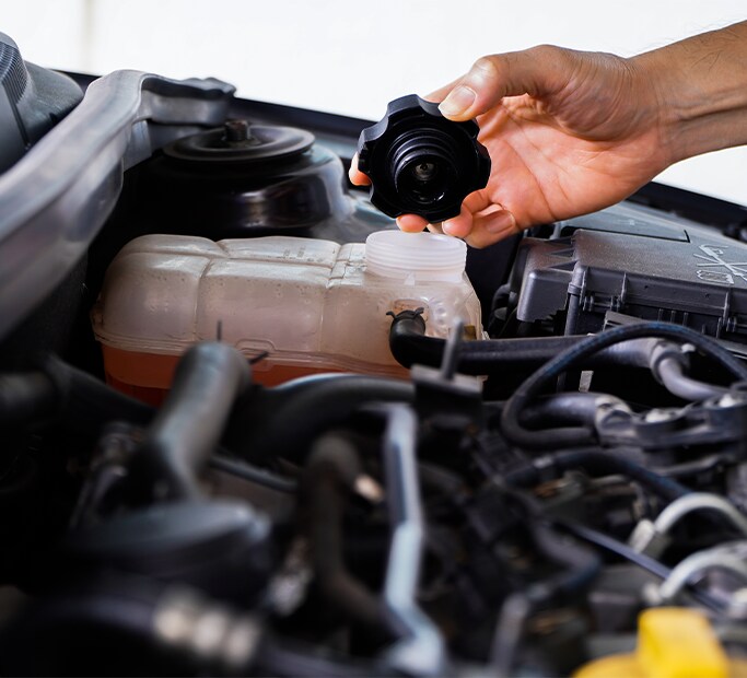 How to Get Your Car Summer Ready at Bobby Rahal Toyota in Mechanicsburg, PA | Person checking fluid levels of a radiator reservoir 