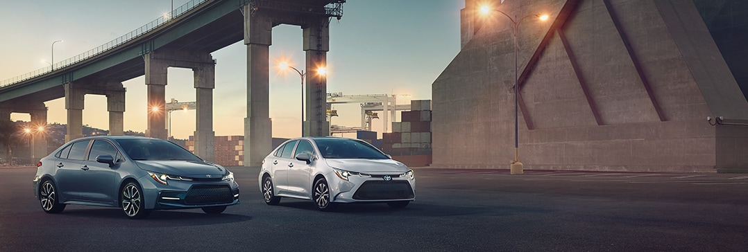 Compare the 2022 Toyota Corolla vs. the 2021 Subaru Impreza at Bobby Rahal Toyota | Two Corollas parked under urban bridge