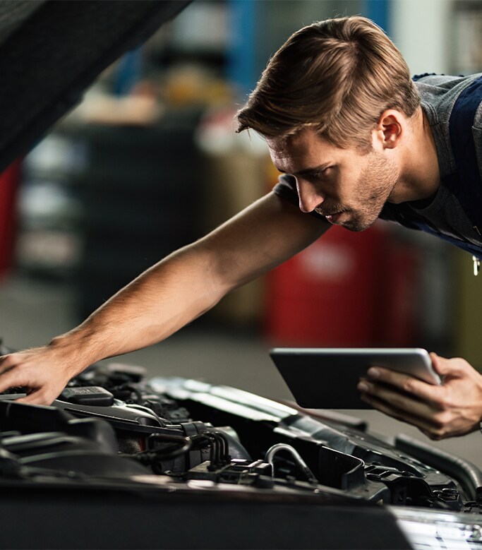 Best MPG At  Bobby Rahal Toyota in Mechanicsburg, PA | Mechanic is inspecting car engine while holding an ipad with information on it 