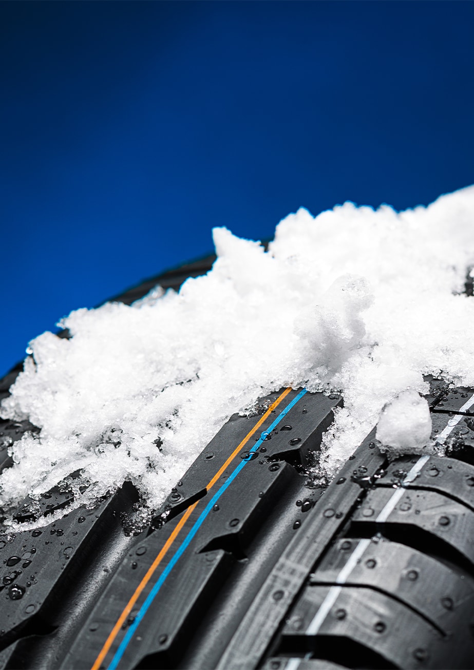 The Cold Facts of Winter Tires | Bobby Rahal Toyota in Mechanicsburg, PA | Close up of snow piled on top of snow tires with a blue background 
