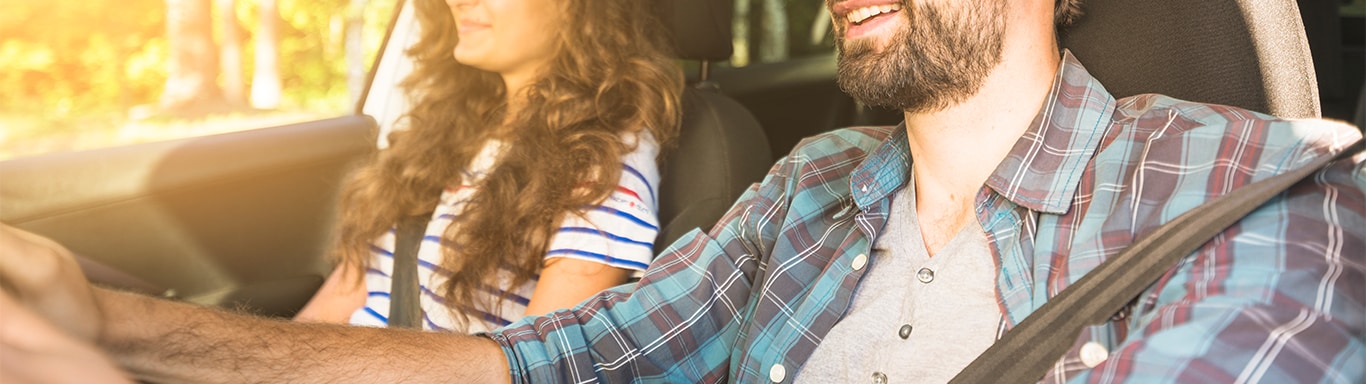 Best MPG At  Bobby Rahal Toyota in Mechanicsburg, PA | Couple driving together in a car while smiling during a sunny day