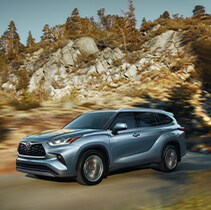 Model Features of the 2021 Toyota Highlander at Bobby Rahal Toyota | Highlander driving fast past rocky mountains