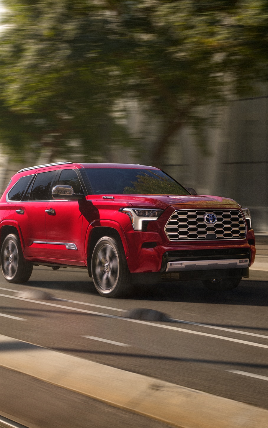 2023 Toyota Sequoia at Bobby Rahal Toyota in Mechanicsburg, PA | Front view Red 2023 Toyota Sequoia driving down a city road during the day 