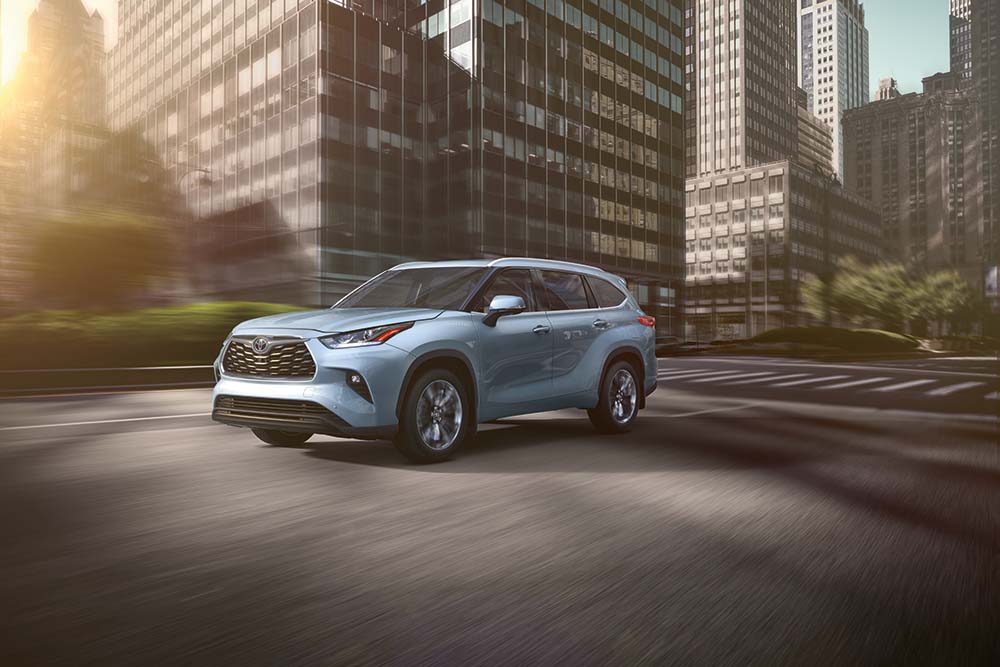 Why drivers should consider an extended warranty on their Toyota at Bobby Rahal Toyota | 2021 Toyota Highlander driving past buildings in town