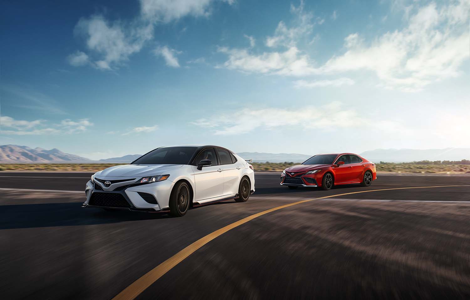 The All-New 2022 Toyota Camry at Bobby Rahal Toyota in Mechanicsburg, PA | Two 2022 Toyota Camry models driving on the race track