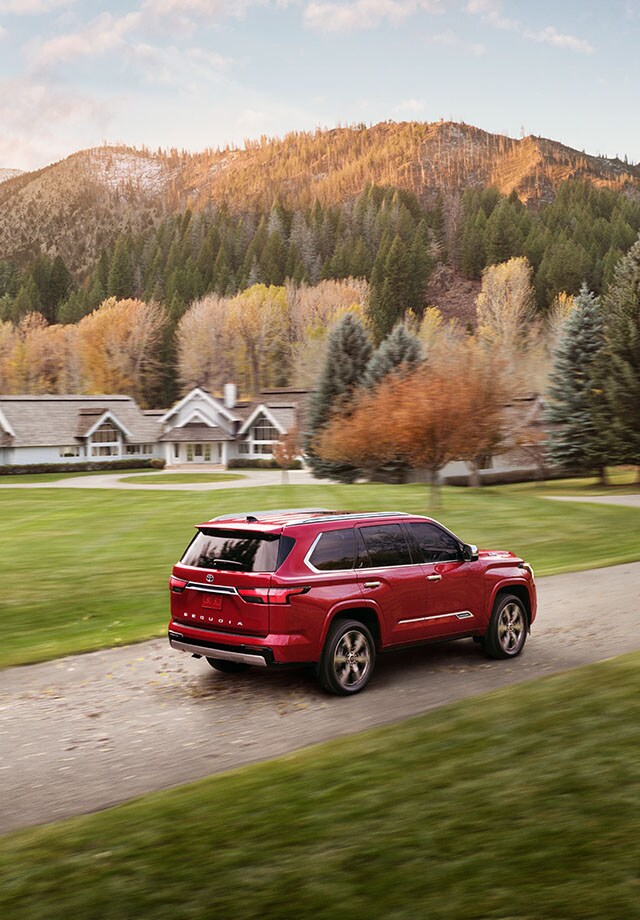 Model Features of the All-New 2023 Toyota Sequoia at Bobby Rahal Toyota | Red 2023 Toyota Sequoia Driving up Driveway to Family Home in Woodlands