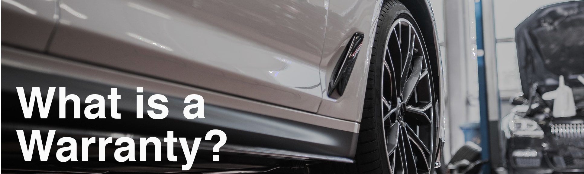 Vehicle Warranty Information at Bobby Rahal Toyota in Mechanicsburg, PA | Grey car in the shop for repair with title in front that reads 'What Is a Warranty?'