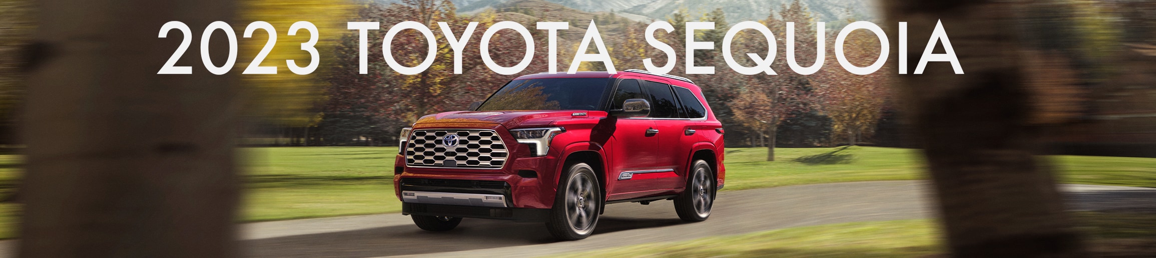 2023 Toyota Sequoia at Bobby Rahal Toyota in Mechanicsburg, PA | Rear 2023 Toyota Sequoia driving down a road during the day with white text on top reading '2023 Toyota Sequoia'
